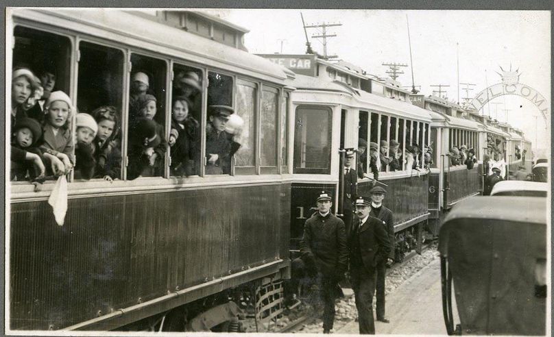 Black and white photo of people in streetcars.