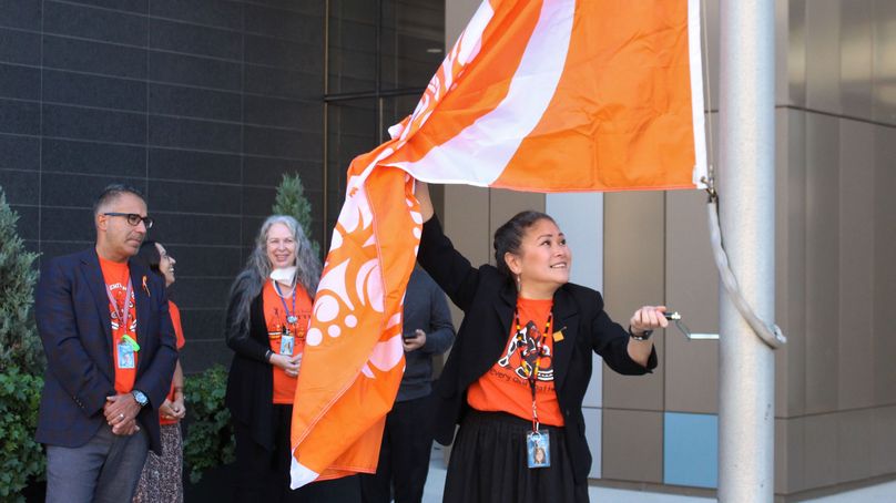 Une femme hisse le drapeau orange.